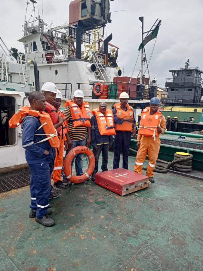 Crew in life jackets and hard hats at a deck briefing